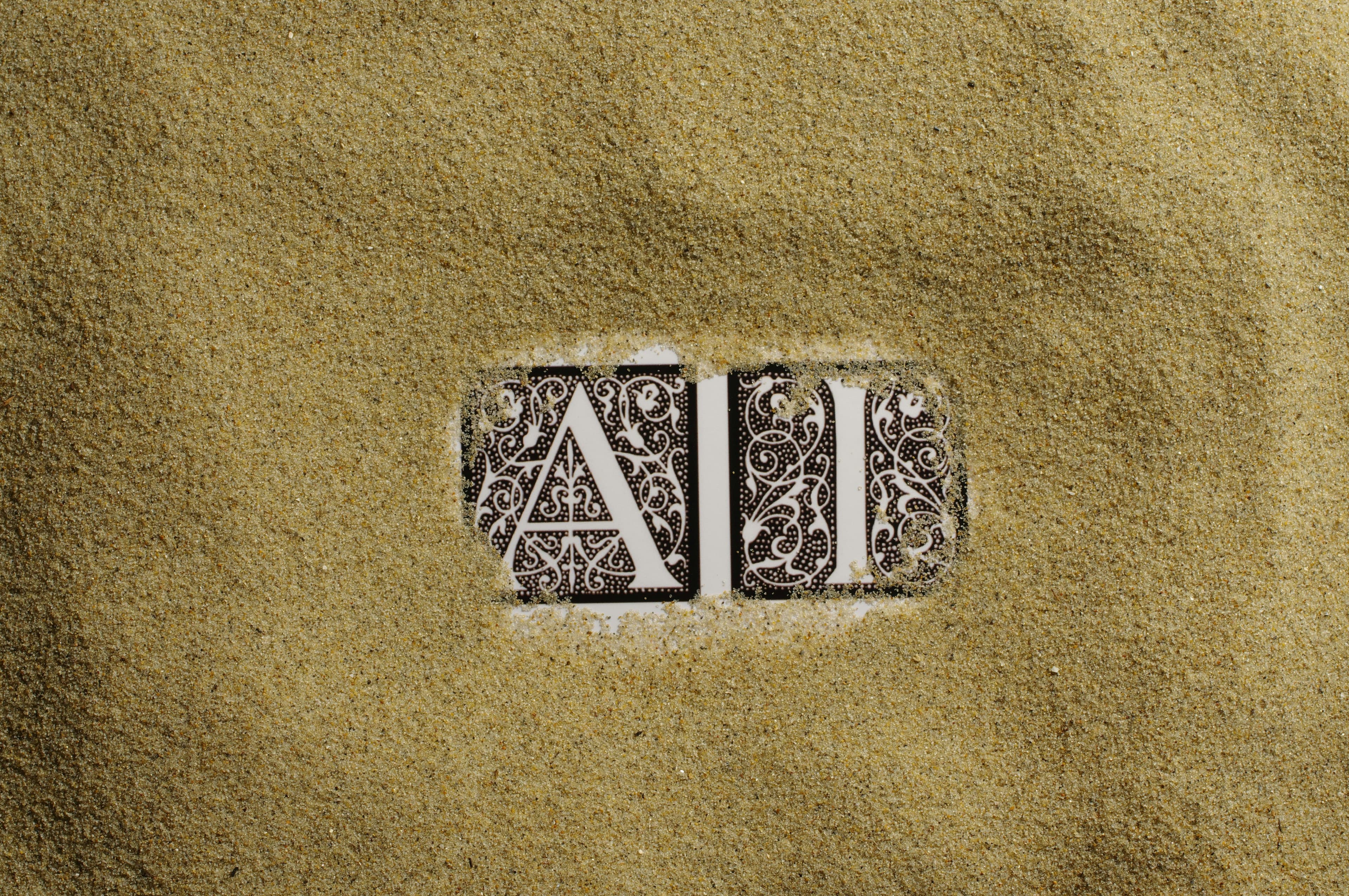 Ai written in tiles covered in sand